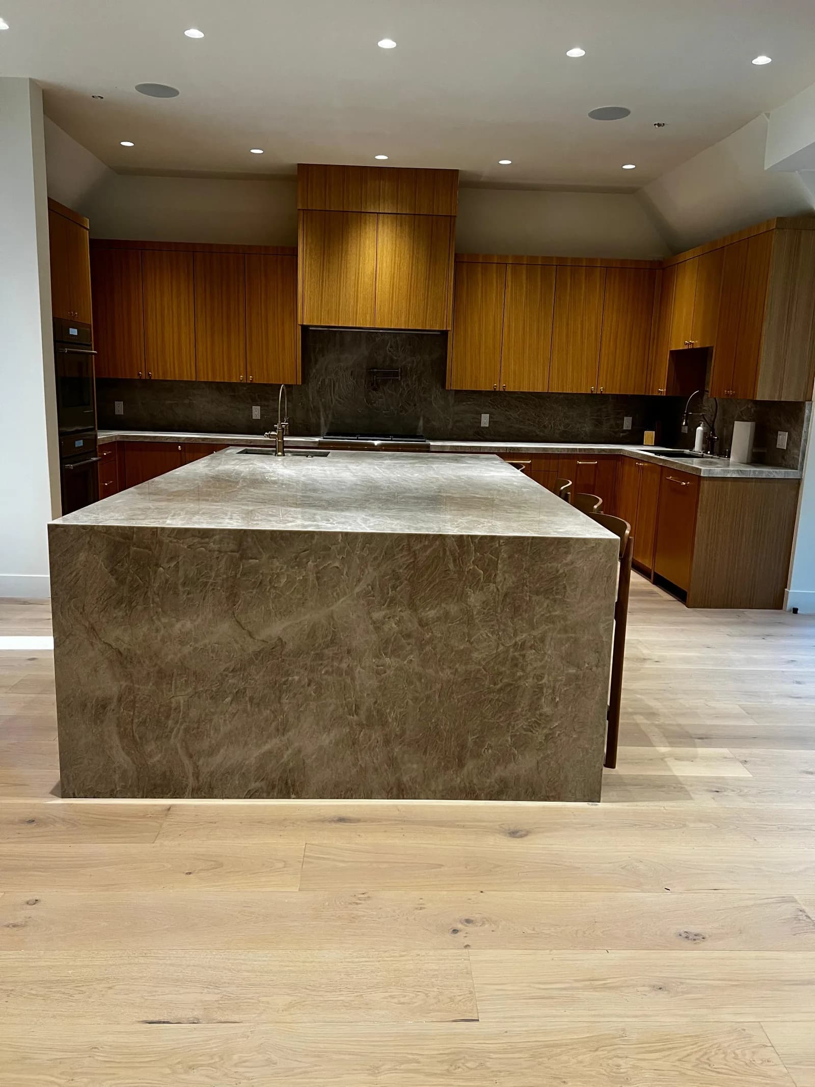 Open-concept kitchen remodel with stone island and hardwood floors