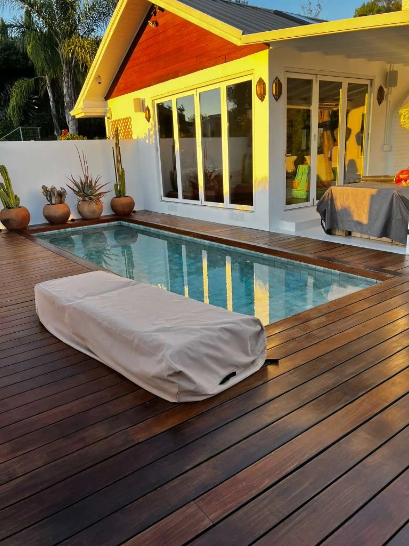 Pool with wraparound wood deck at golden hour
